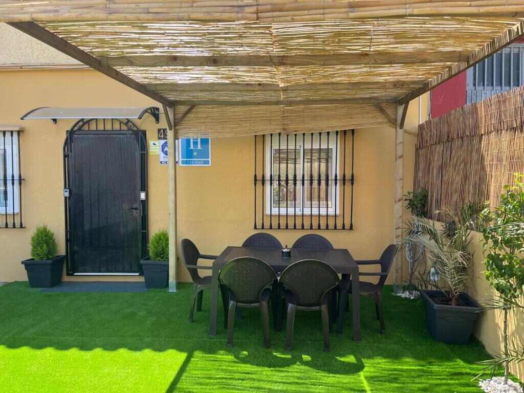 Shaded terrace with outdoor furniture at Hostal NV Airport